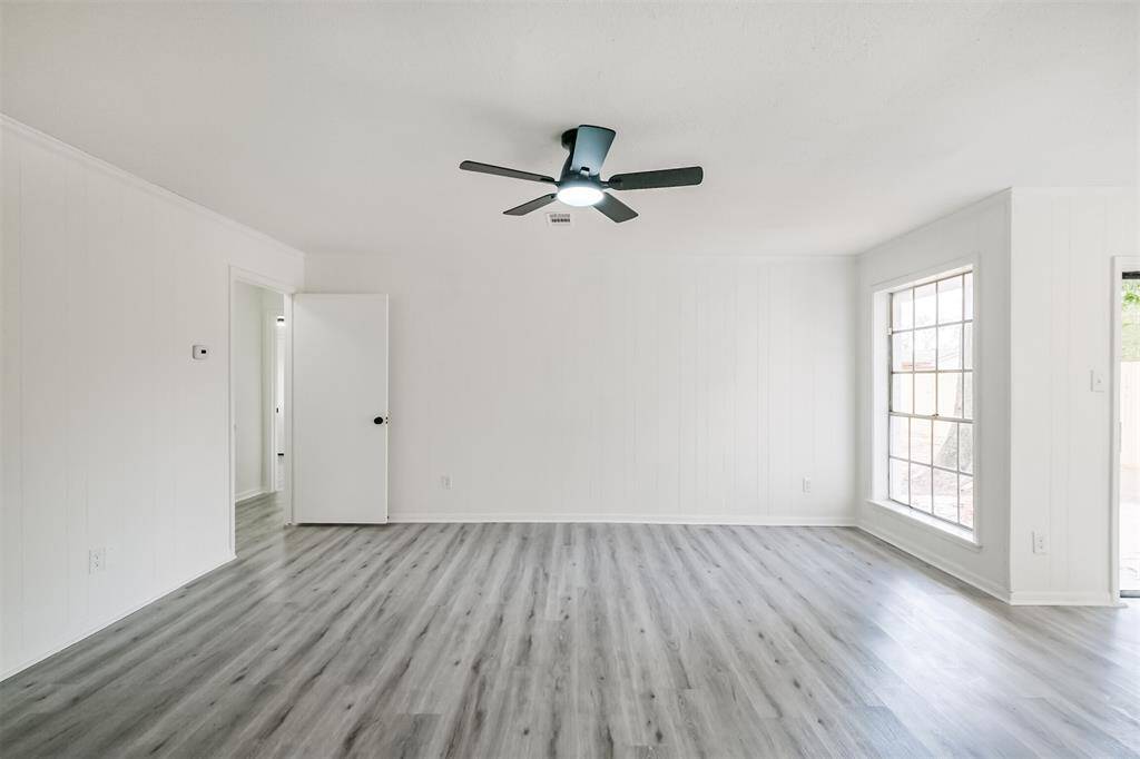Spacious family room featuring a ceiling fan and light fixture.