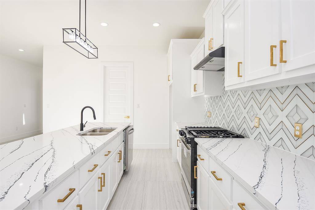 This gourmet kitchen features a gas cooktop with a vented hood and a sleek single oven, perfect for any home chef.