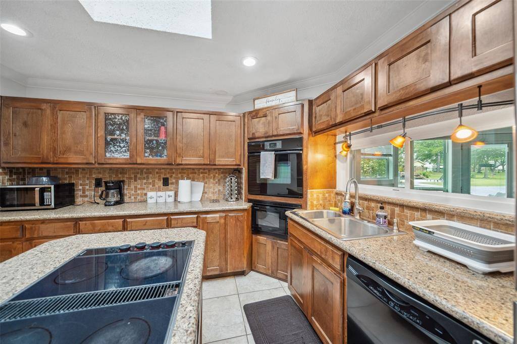 Kitchen has a skylight and modern windows above the sink which allow for ample natural light.