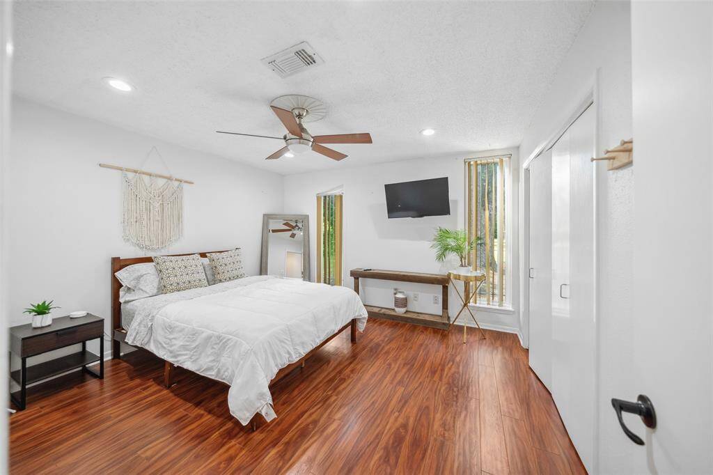 Spacious secondary bedroom with modern ceiling fan and no carpet.