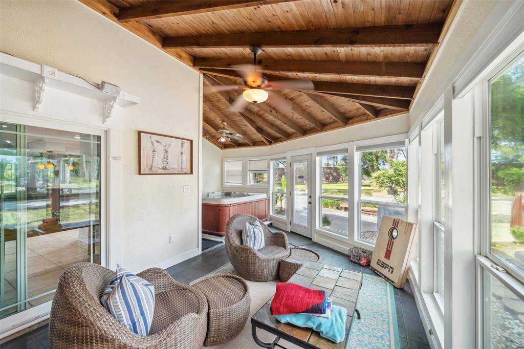 Sunroom has an operational hot tub, beautiful wood and exposed beam ceiling.