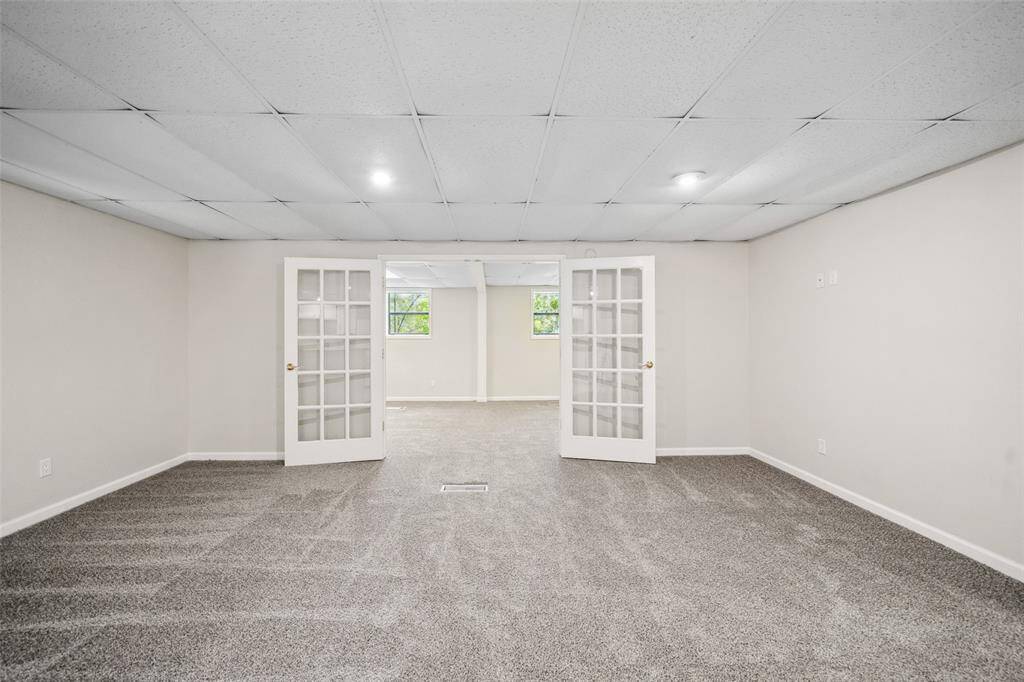French doors lead to another large bedroom or flex room.