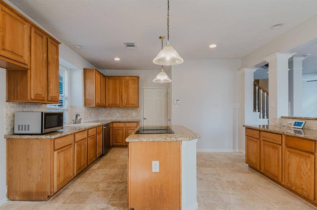 "Bright kitchen with granite countertops, offering plenty of room for meal prep and cooking.