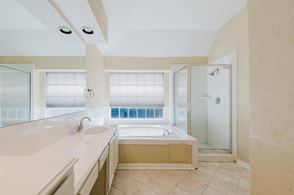 Primary bath featuring an extra-long vanity, along with a separate tub and shower for added comfort.