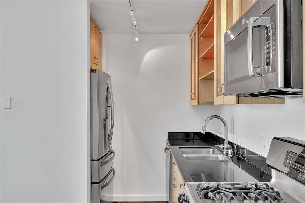 Upgraded refrigerator on left is included in sale. Additional storage cabinets above refrigerator.  GAS COOKING which is a rarity in urban loft living!  Remember for the times you aren't in the mood to cook that there are numerous restaurants in surrounding blocks for take out or dine-in!