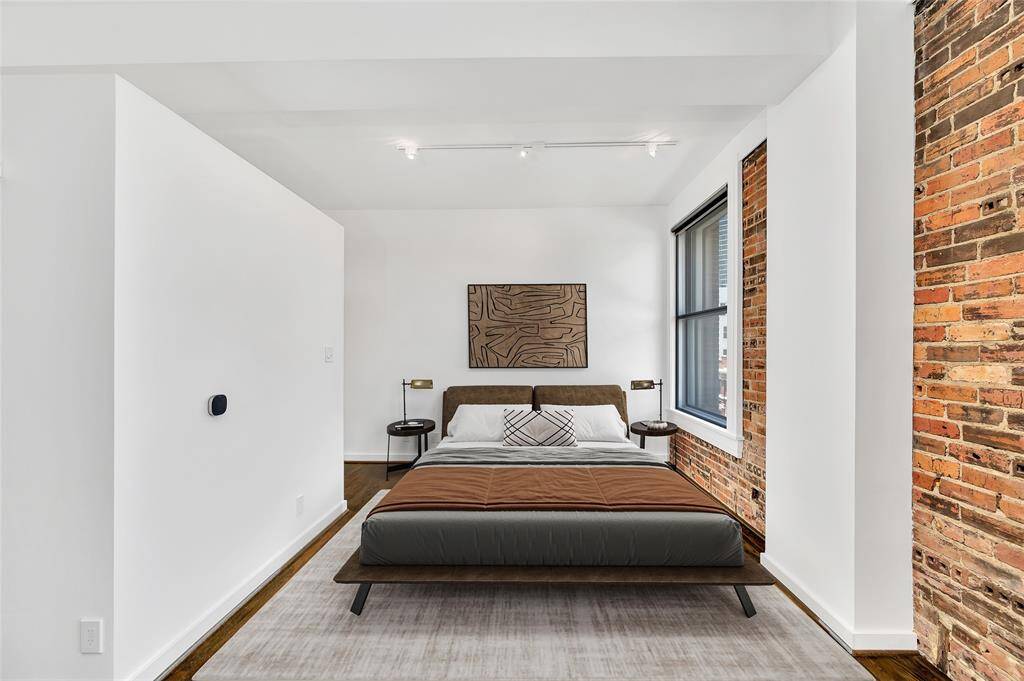 Bedroom area is in an alcove that is open to Living area, which gives it a sense of separation while not making the space feel cramped or dark. PHOTO VIRTUALLY STAGED.