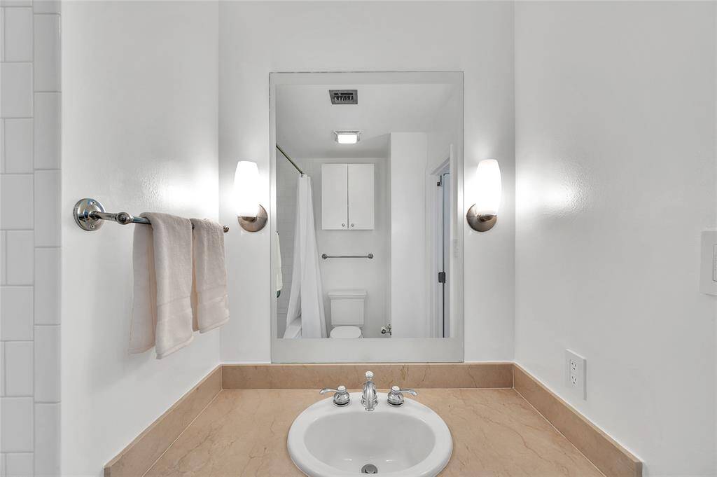 Decorative mirror above Bathroom sink is flanked with a pair of sconces adding style and illumination to the space!