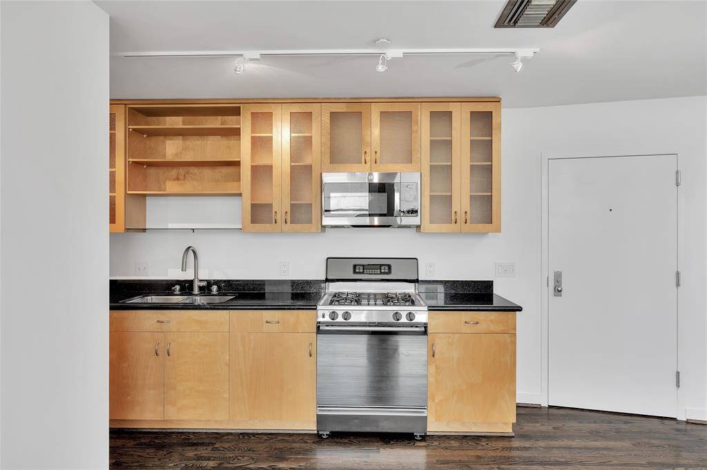 Kitchen boasts maple cabinetry with upper cabinets having diffused glass doors and open shelving above the sink. Solid granite countertops, stainless steel appliances and double bowl undermount stainless steel sink. Microwave replaced 2024, refrigerator & dishwasher replaced 2018. (All per Seller).
