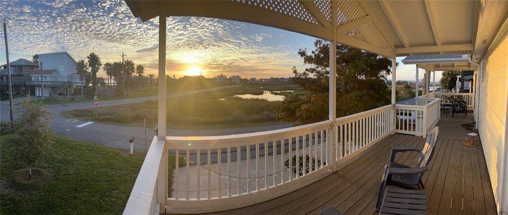 Charming home with a spacious porch offering stunning views of the sunset over a tranquil coastal landscape. Ideal for relaxation and enjoying the serene surroundings.