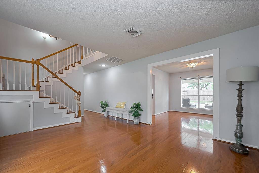 From the entry, looking through the Formal Dining room you look out to the porch and backyard pool!  The stairs leading to the 4 bedrooms is on the left.