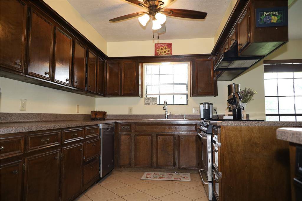 This photo shows a spacious two-story brick home with a well-maintained lawn and mature trees. It features a large driveway leading to a two-car garage, providing ample parking space. The house is set in a peaceful neighborhood.