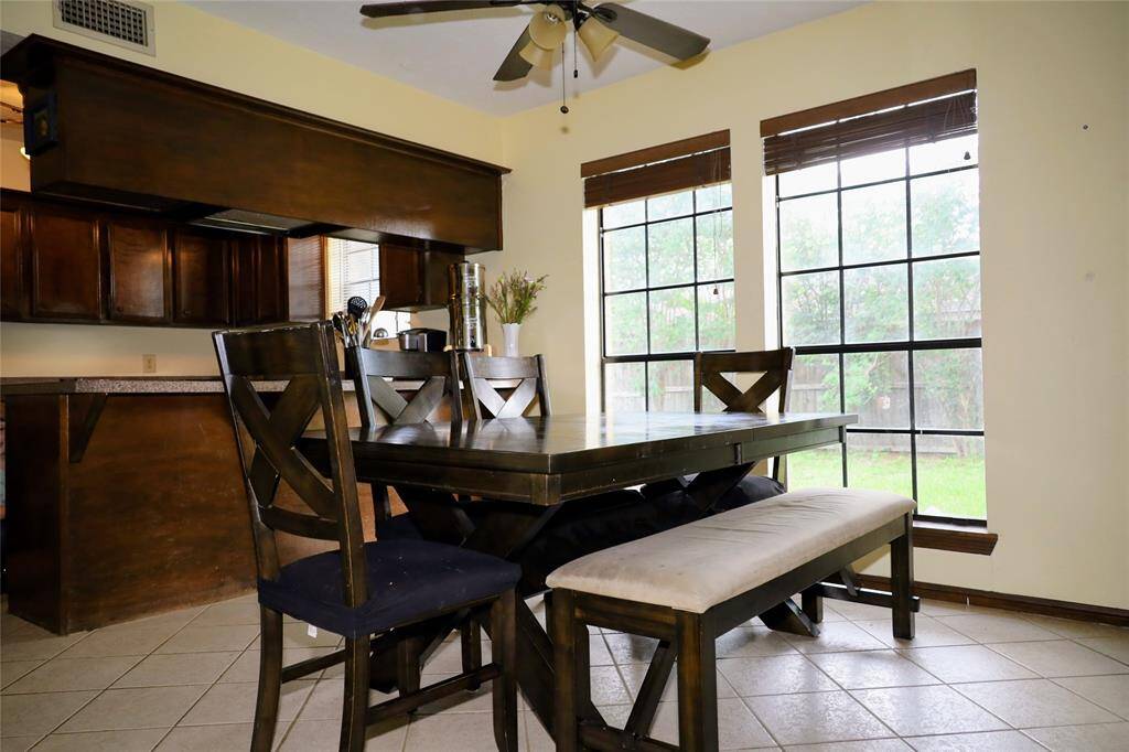 This photo shows a spacious two-story brick home with a well-maintained lawn and mature trees. It features a large driveway leading to a two-car garage, providing ample parking space. The house is set in a peaceful neighborhood.