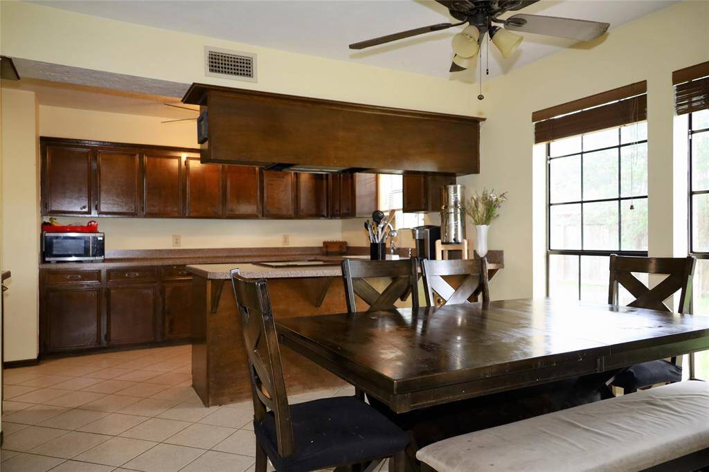 This photo shows a spacious two-story brick home with a well-maintained lawn and mature trees. It features a large driveway leading to a two-car garage, providing ample parking space. The house is set in a peaceful neighborhood.
