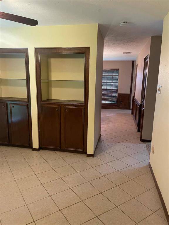 This photo shows a spacious two-story brick home with a well-maintained lawn and mature trees. It features a large driveway leading to a two-car garage, providing ample parking space. The house is set in a peaceful neighborhood.