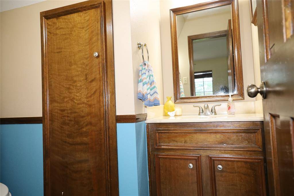 This photo shows a spacious two-story brick home with a well-maintained lawn and mature trees. It features a large driveway leading to a two-car garage, providing ample parking space. The house is set in a peaceful neighborhood.