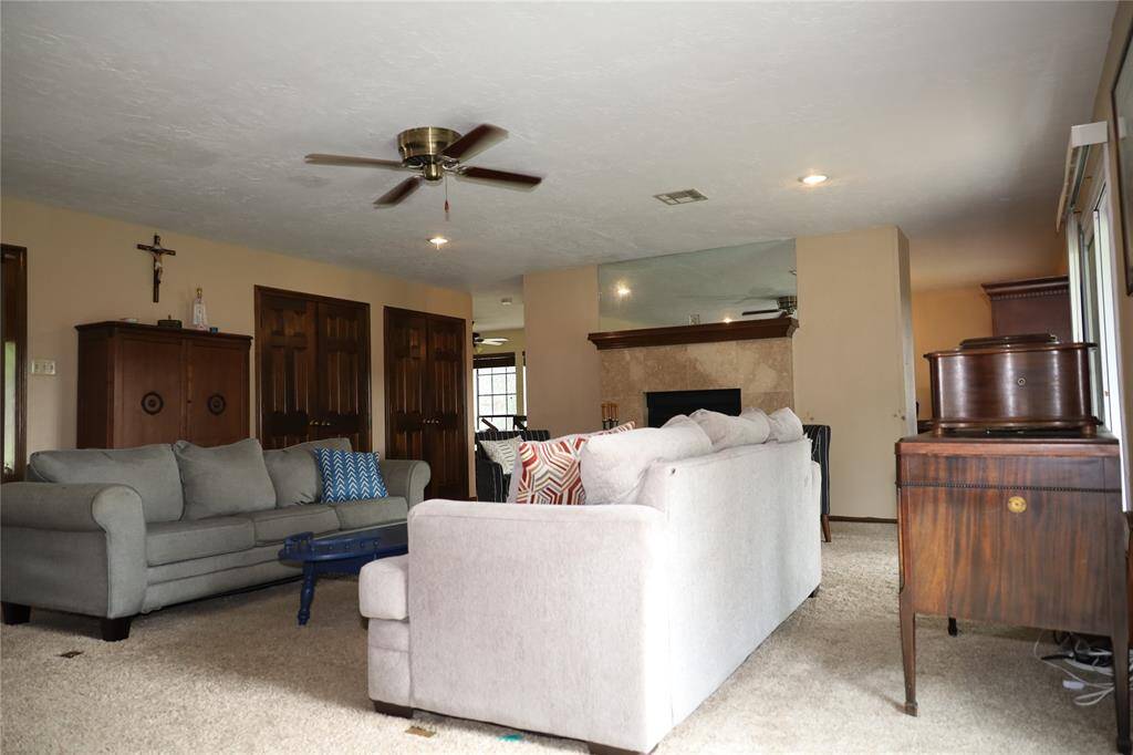 This photo shows a spacious two-story brick home with a well-maintained lawn and mature trees. It features a large driveway leading to a two-car garage, providing ample parking space. The house is set in a peaceful neighborhood.