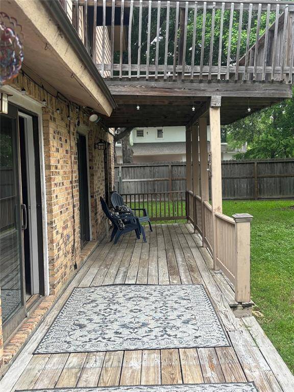 This photo shows a spacious two-story brick home with a well-maintained lawn and mature trees. It features a large driveway leading to a two-car garage, providing ample parking space. The house is set in a peaceful neighborhood.