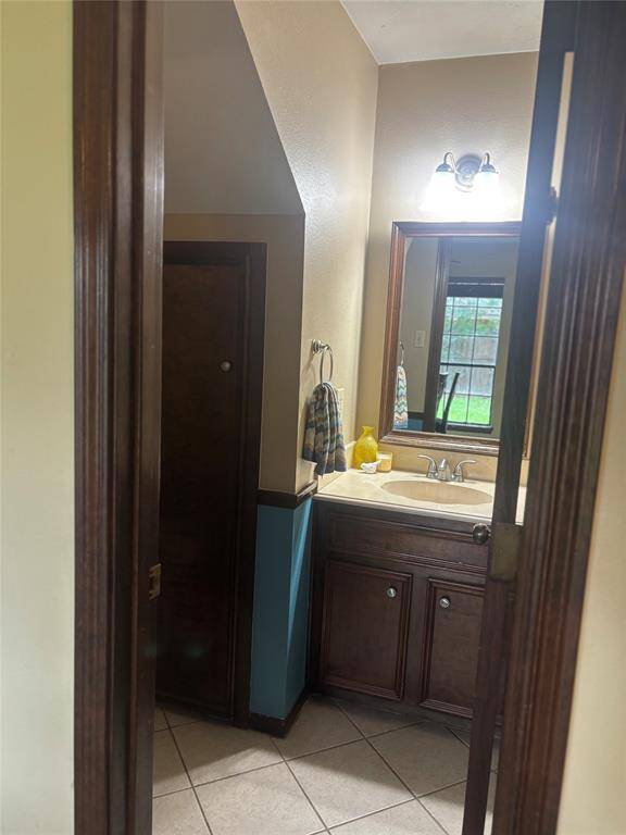 This photo shows a spacious two-story brick home with a well-maintained lawn and mature trees. It features a large driveway leading to a two-car garage, providing ample parking space. The house is set in a peaceful neighborhood.