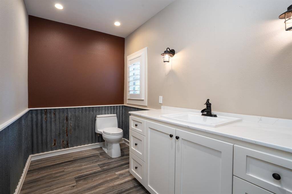 Powder bath has quartz counter and updated fixtures.