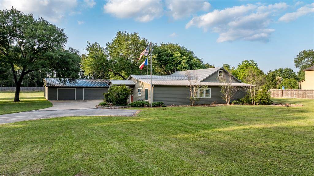 Nestled amongst mature trees the one story has a metal roof and Hardi-Plank siding.