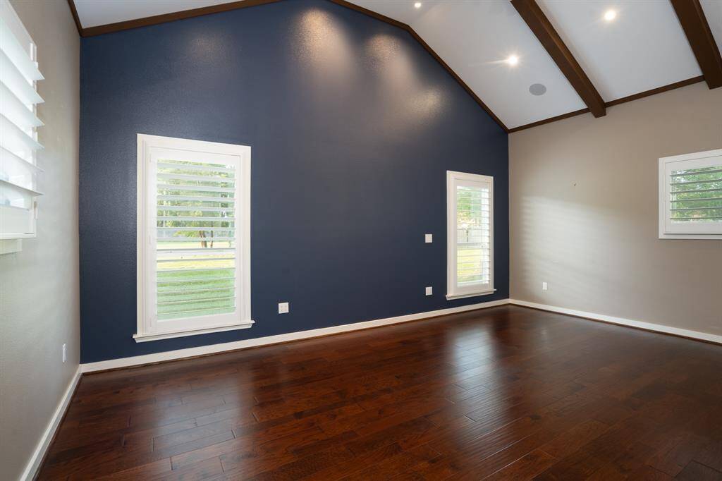 Gorgeous primary bedroom has a vaulted beamed ceiling.