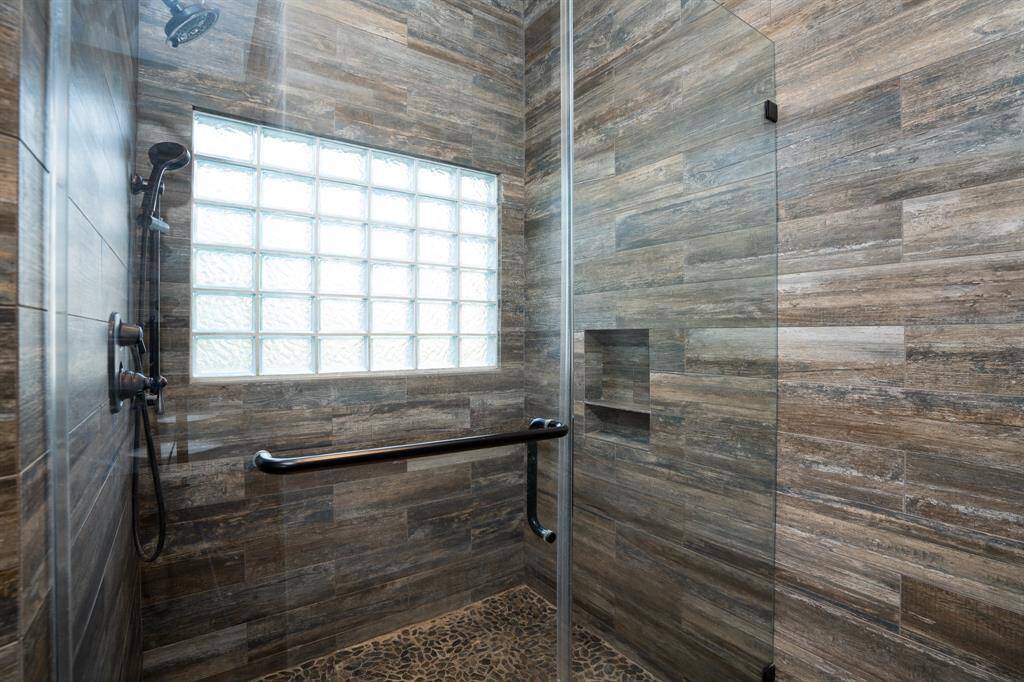 Walk-in frameless shower with a pebble floor.
