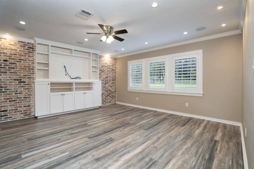 Living space with custom built-in entertainment center and brick accent wall.