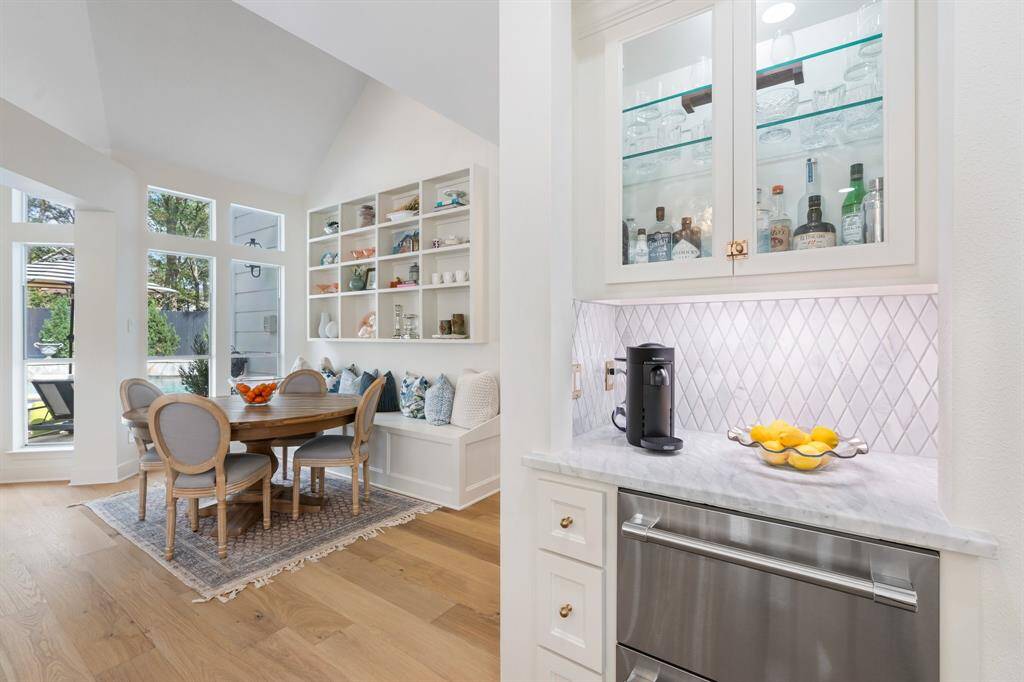 A convenient coffee bar area with glass front storage, marble counter, marble backsplash and to drink drawers complete the space.