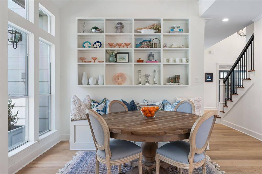 The inviting breakfast area showcases custom wall shelves, perfect for displaying your favorite collectibles. Space underneath the staircase was also opened for additional storage.