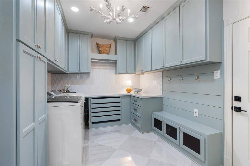 Functional, practical and relaxing? This laundry room has it all! Fully remodeled and outfitted with plenty of cabinets, cubbies, and pull out drying drawers - all painted in a relaxing hue.