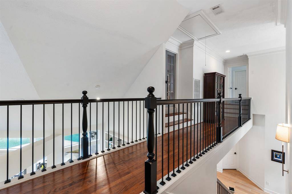 Newly painted rails in Iron Ore compliment warm wood flooring on the second floor landing.
