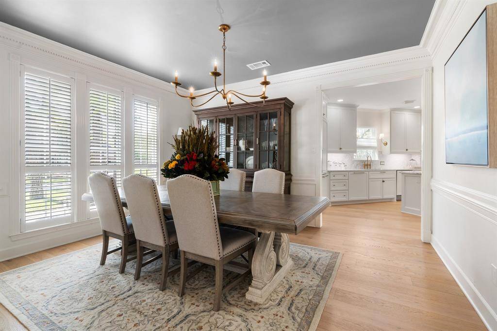 The formal dining features timeless mouldings, updated light fixture and expanded opening to the kitchen.