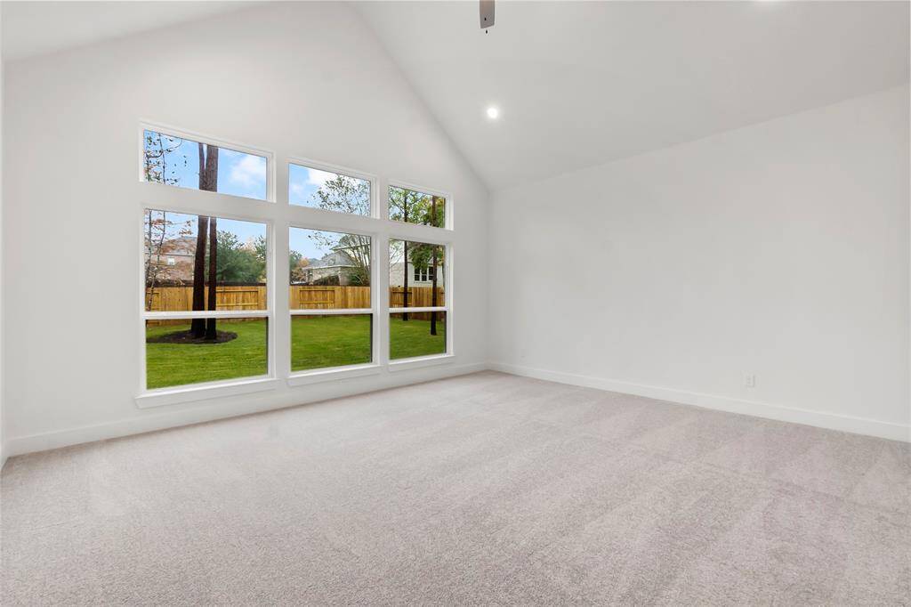 Primary Bedroom with Vaulted Ceiling, Serene Views of the Wooded Back Yard, 2 Walk-in Closets, and Fan.