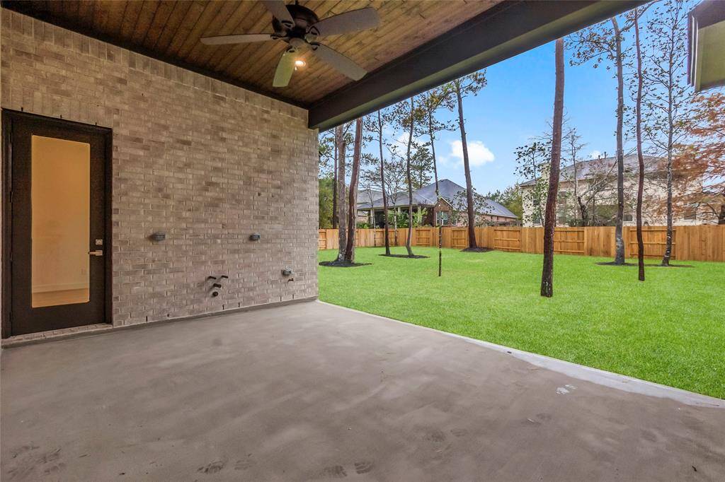 Covered Rear Patio with Fan, Gas Line, Water Line, Electric Outlet, and Gorgeous Pine Ceiling.