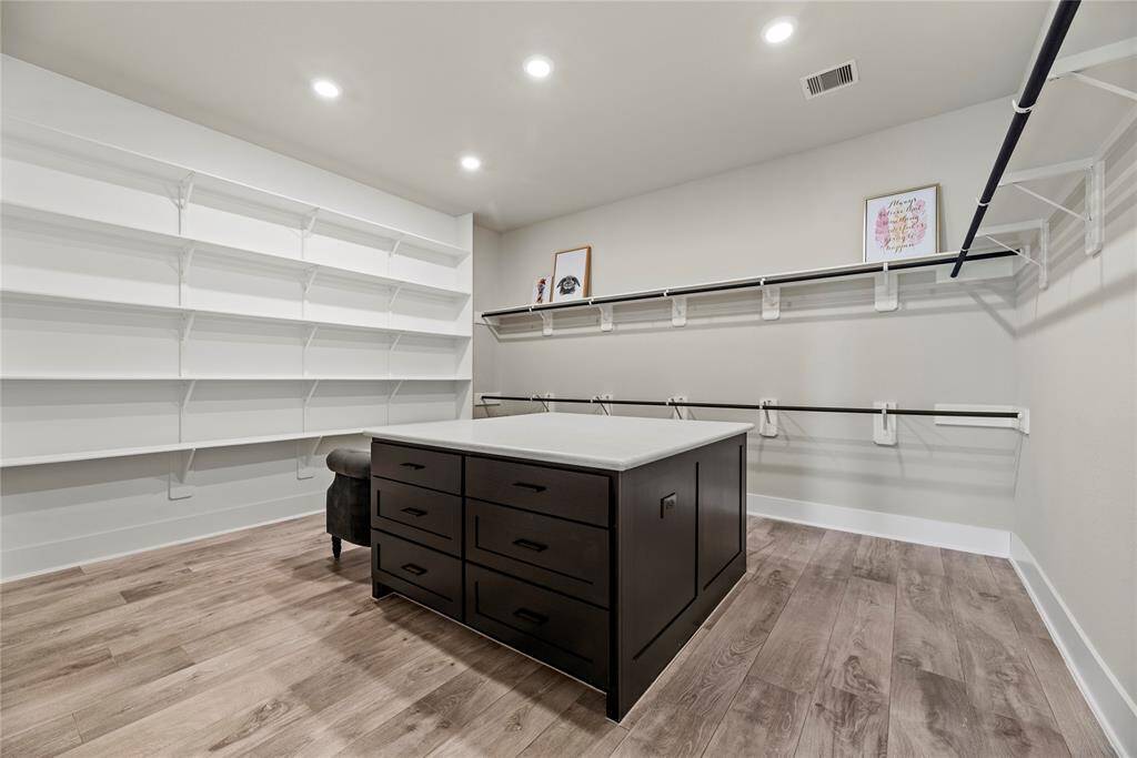 The spacious primary suite offers ultimate comfort and convenience, featuring separate his and hers walk-in closets—including a luxurious hers closet complete with a center island for added storage and style.