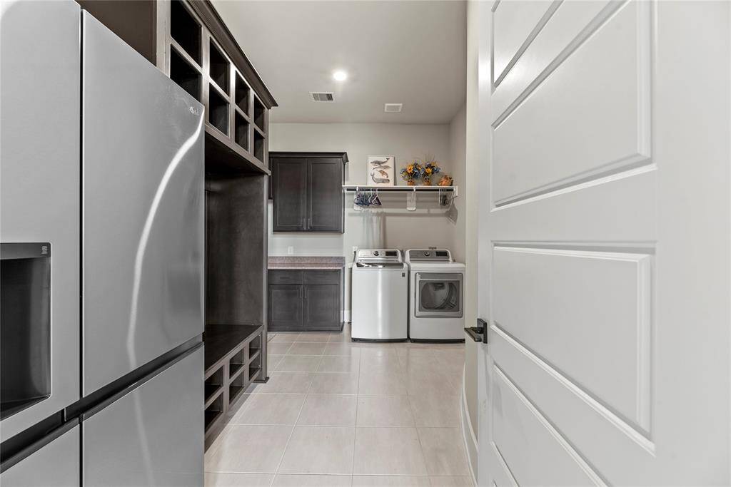 Boasting a laundry room with a hanging bar and a shelf, there is a load of room for cleaning supplies and clothing organization.