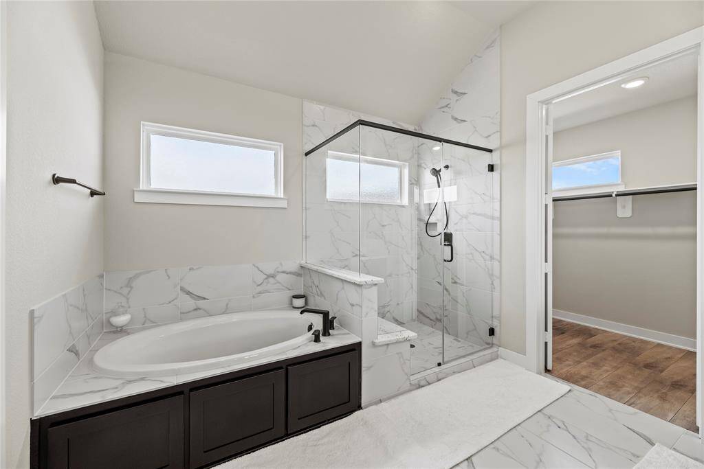 Custom tile flooring flows directly into the shower surround with seamlessness and perfect harmony.