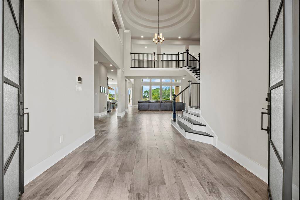 Grand and spectacular, the two-story foyer makes an impression on all your guests! Richly toned hardwood floors gleam in the presence of luminous natural light, while the above light fixture adds a touch of luxury.