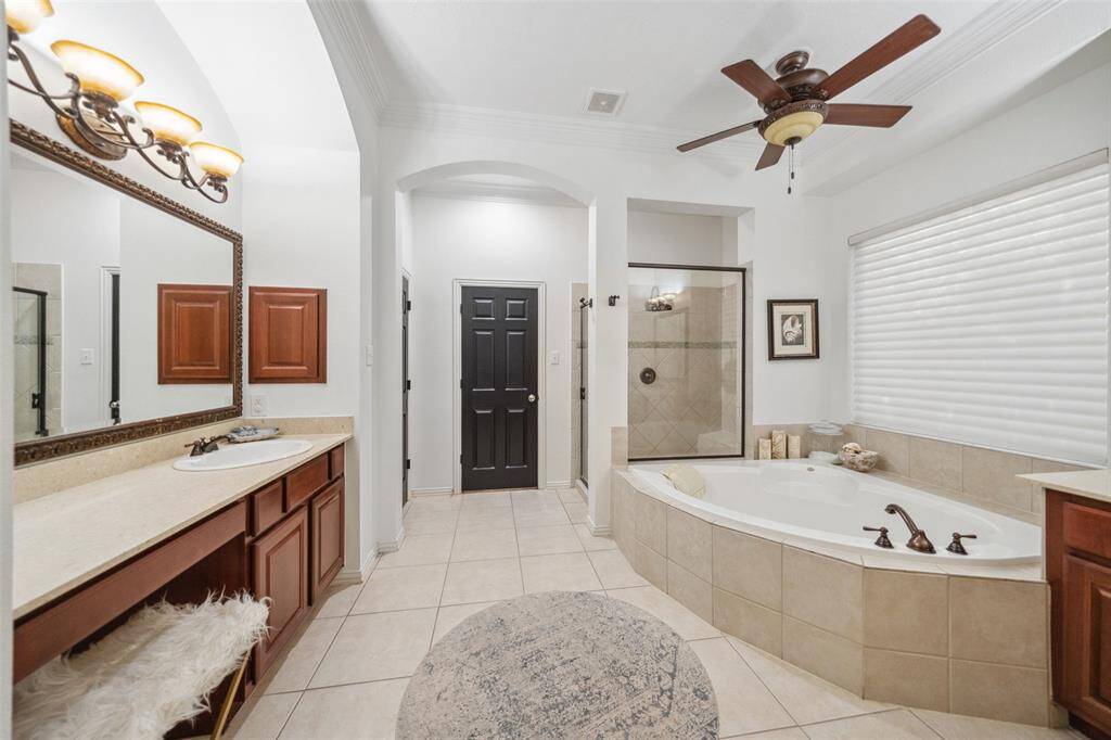 PRIMARY BATH Deep soaking tub, water closet & vanity seating with two sink consoles & a larger shower & closet.
