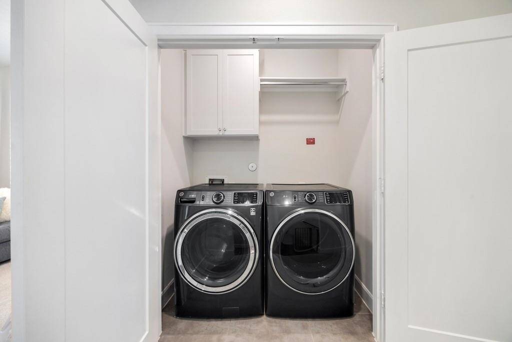 The third-floor primary suite offers a tray ceiling, two spacious walk-in closets, and plenty of natural light.