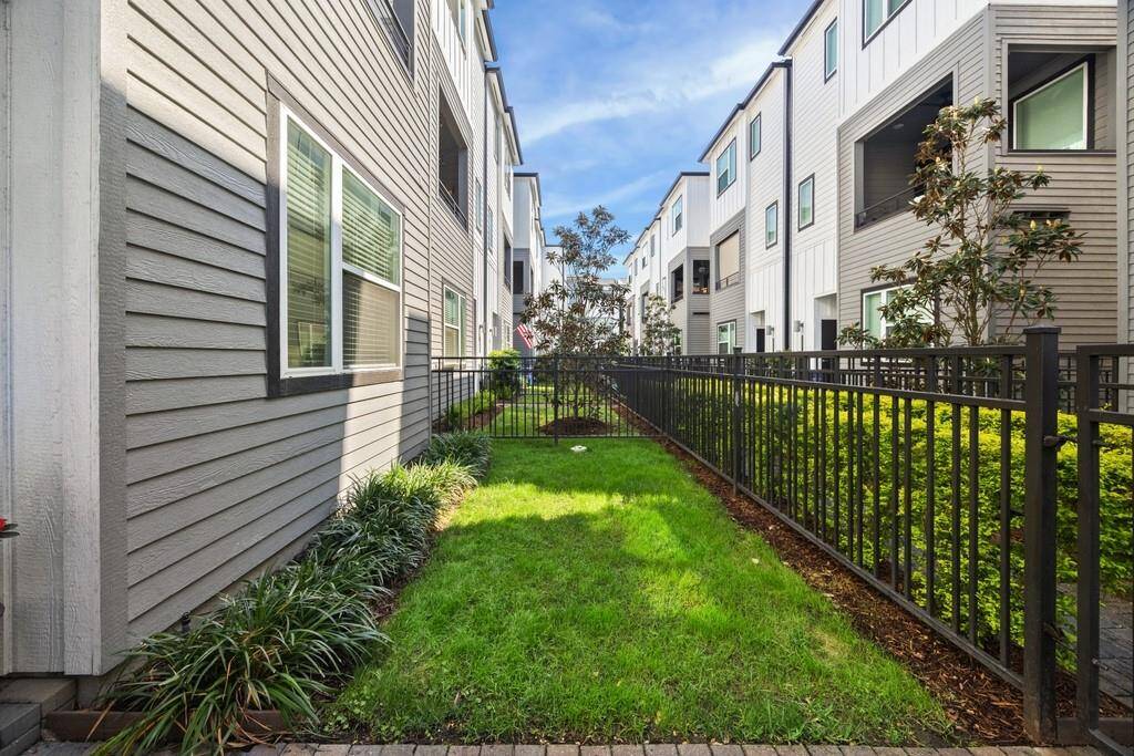 Alternate view of this lock-and-leave home highlights the private entrance to the third bedroom suite on the first floor—ideal for rental income or multi-generational living.