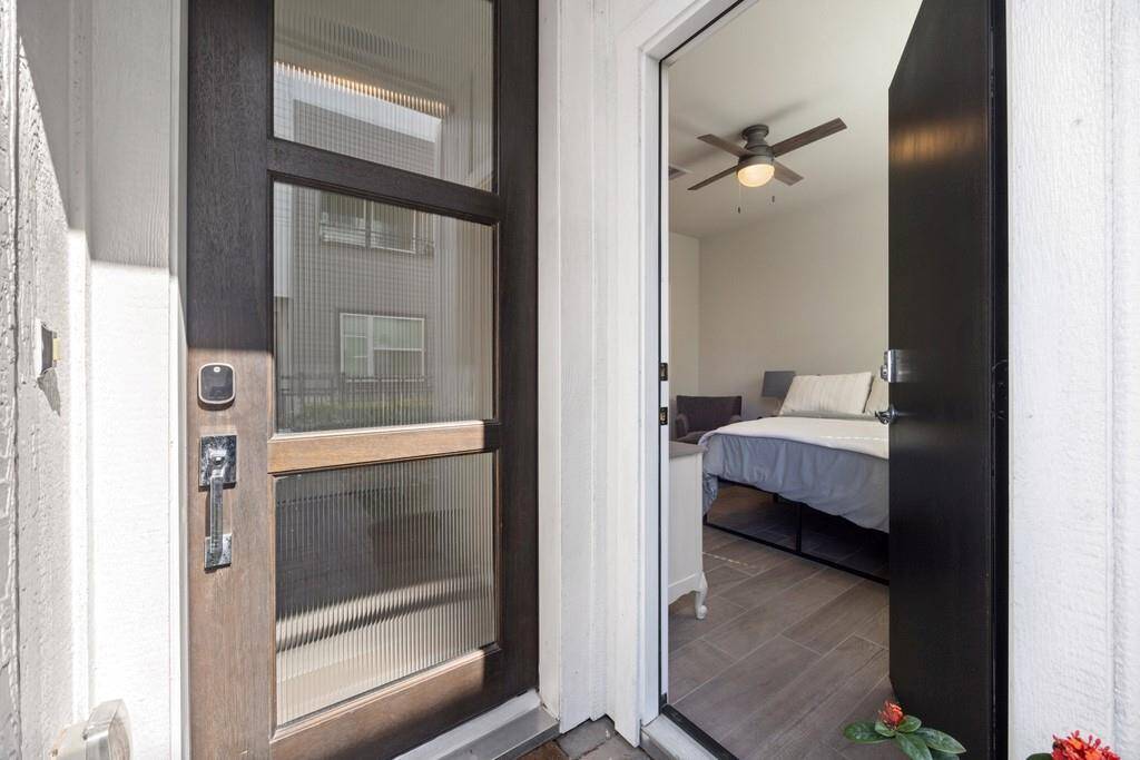 Interior entry showcases a sleek design with an iron-railed staircase, abundant natural light, and a convenient closet.