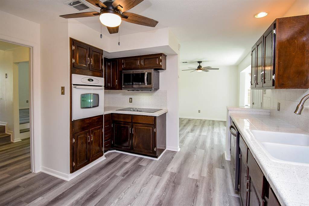It also features an abundance of wood cabinetry, an electric cooktop, and a gorgeous tile backsplash!