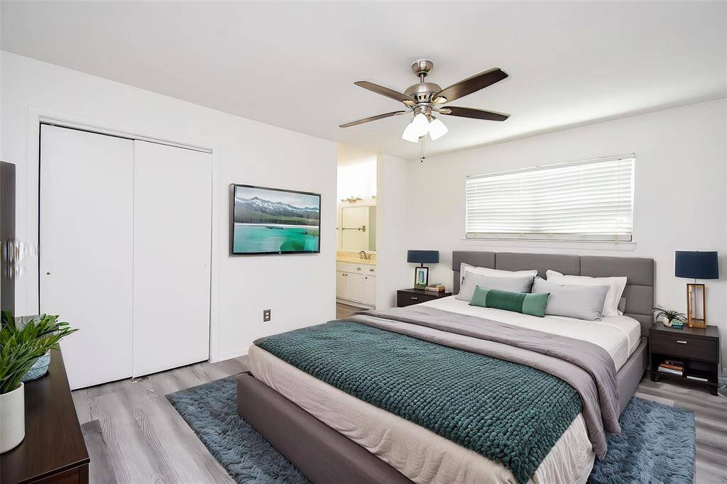 Virtually Staged: Come home and unwind in this AMAZING master suite! Featuring laminate floors, built-in closet, window with privacy blinds, and dark stained ceiling fan.