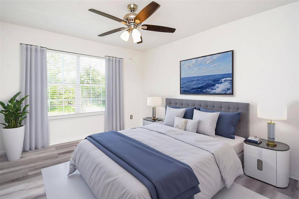 Virtually Staged: This secondary bedroom features neutral paint, laminate floors, ceiling fan, and large window with privacy blinds.
