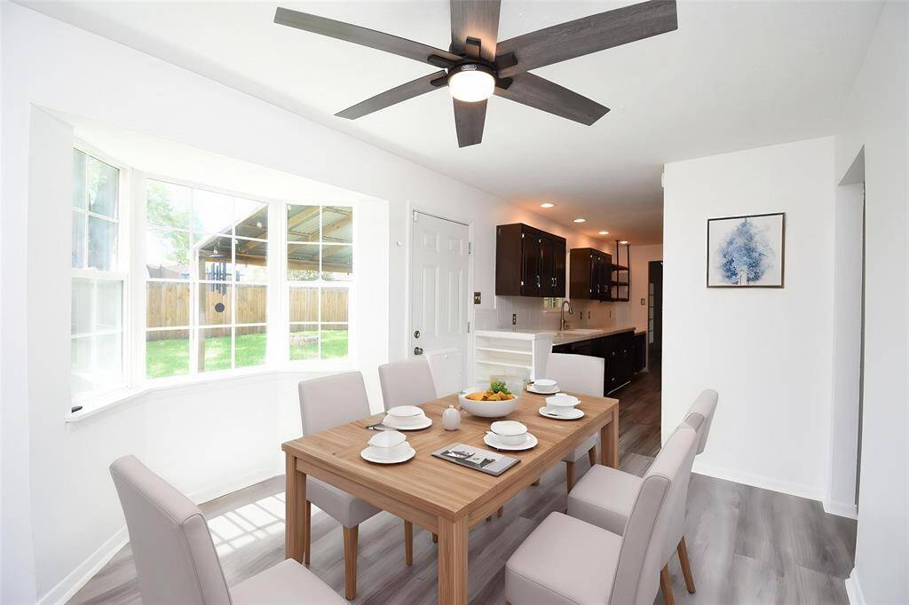 Virtually Staged: Beautiful dining area in this breathtaking home - featuring a dark stained ceiling fan, gorgeous laminate floors, and a large window providing stunning views of the backyard!