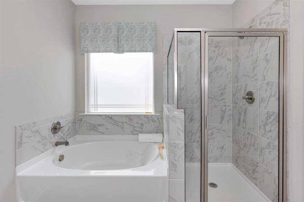 The McGinnis- Primary Bathroom with Garden Tub and Separate Walk-in Shower. Home under construction. Sample floor plan photo used for illustrative purposes only. Upgrades, selections options, windows and colors may vary.