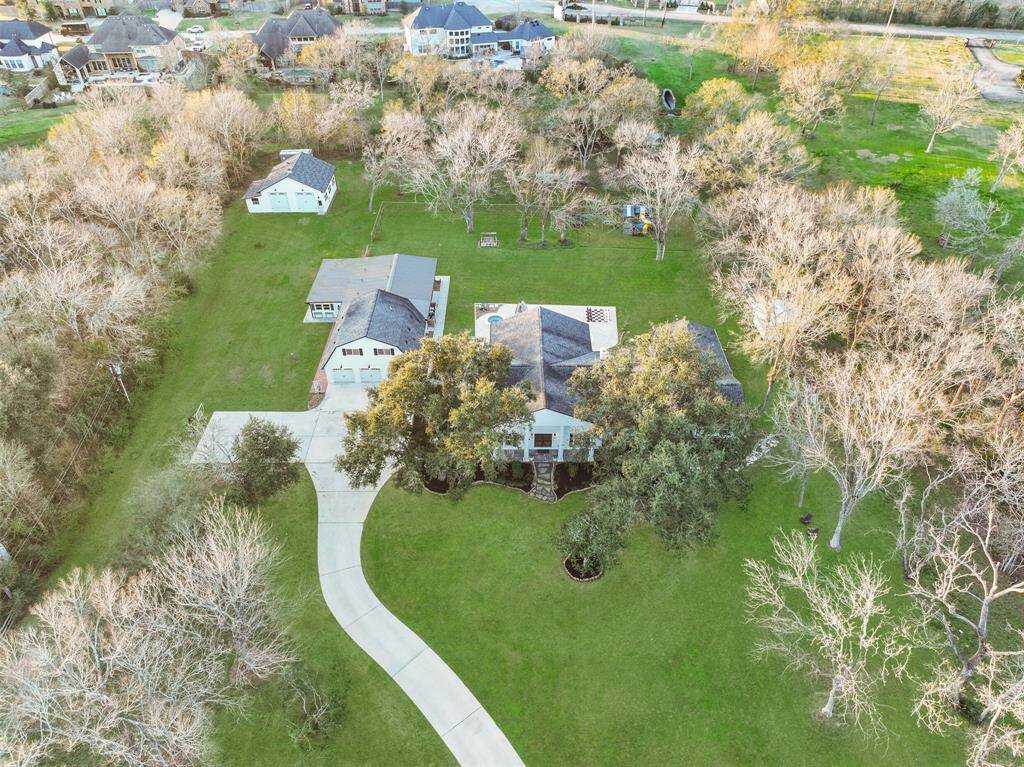 Welcome to 11 Windcreek Street in highly-acclaimed Friendswood ISD! This property is a rare gem - boasting a sprawling 4.45-acre creekfront lot with a beautifully appointed 5000+ square foot home, complete with a pool, outbuildings, and garage space galore!