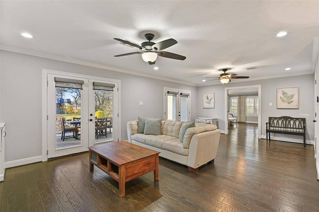 An alternate view of the owners' retreat, as seen from the desk alcove, highlights the two sets of French doors leading out to the covered back patio, pool, spa, sauna, outdoor kitchen, chicken coop, and lush creekfront acreage.