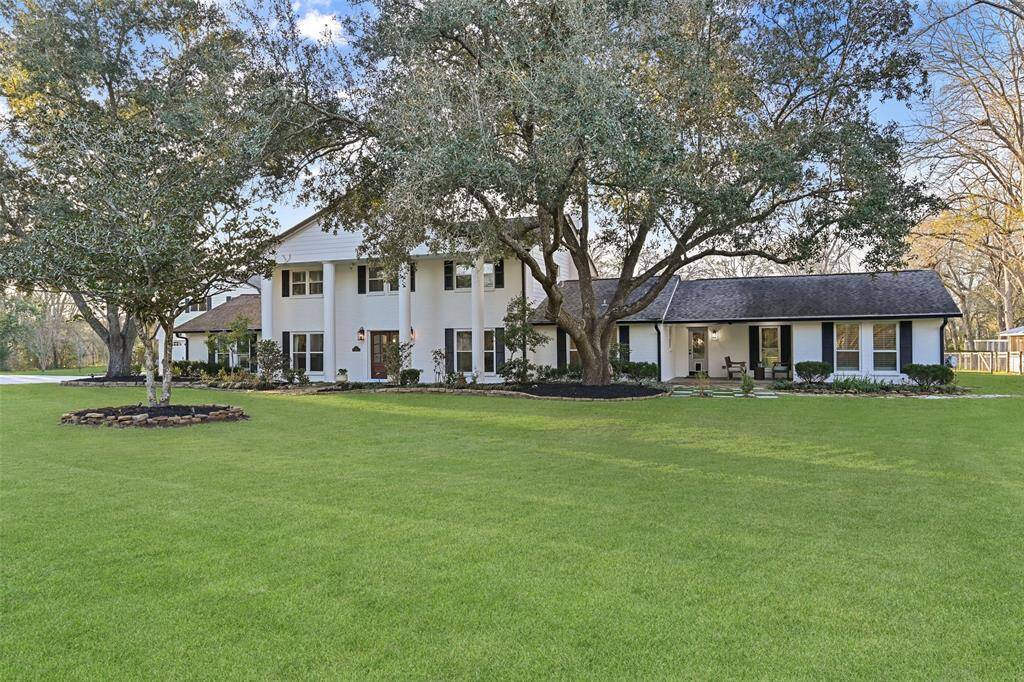 The home is truly grand - boasting a white-painted brick elevation accented by striking black shutters, elegant columns, old-world style carriage lamps,  numerous porches, sprawling trees, and the sounds of nature all around.